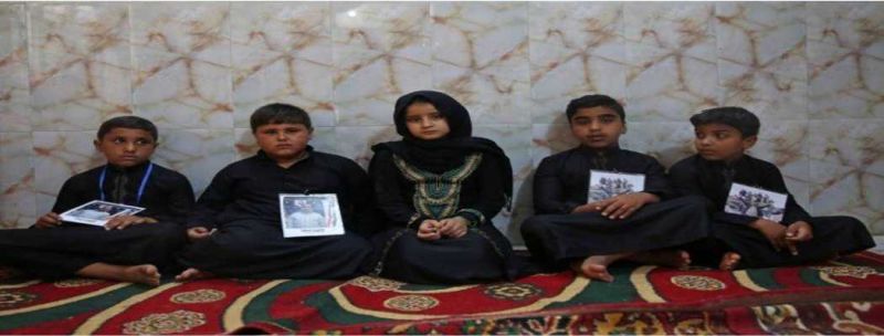 Crianças iraquianas seguram fotos de seus pais, mortos pelo Estado Islâmico após sequestro em estrada em Kirkuk 
