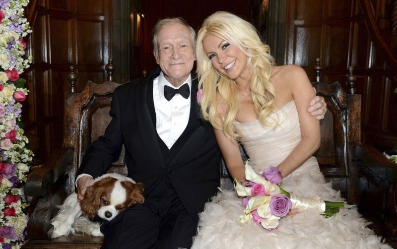 O fundador da 'Playboy', Hugh Hefner, posa com sua nova esposa, a coelhinha Crystal Harris, após o casamento celebrado na Mansão da Playboy, na Califórnia, no último dia de 2012. À esquerda, o cãozinho Charlie também aparece na foto. (Foto: Elayne 