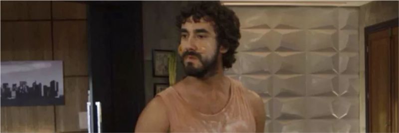 Galdino (Gabriel Godoy) bagunça o apartamento de Jerônimo, na novela 'Verão 90' — Foto: Globo