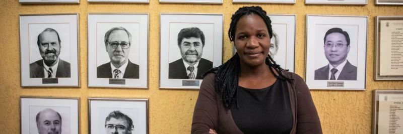 A professora Adriana Alves, diante de retratos dos diretores do Instituto de Geociências da USP 