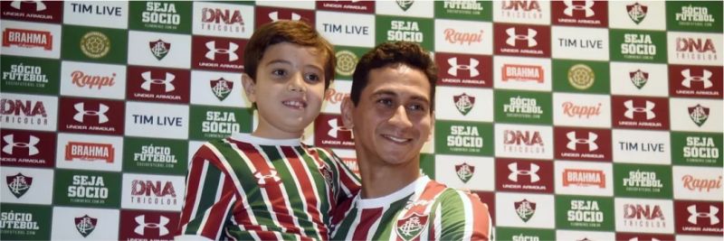 Ganso pega o pequeno torcedor mirim Ricardo, que chamou a atenção durante sua chegada no aeroporto