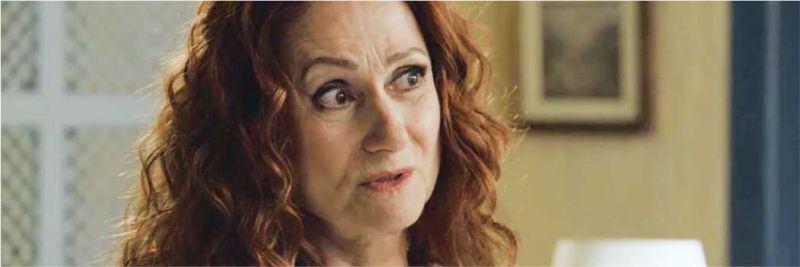 Milu (Zezé Polessa) estranha a chegada de Gabriel (Bruno Gagliasso) em sua loja na novela 'O Sétimo Guardião' 