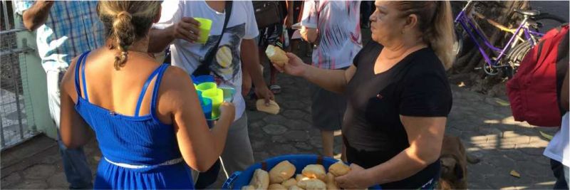 Venezuelanos recebem pão e copo de suco servido por missionárias católicas no Centro de Boa Vista